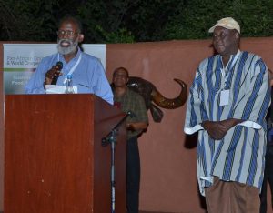 Picture of Dr Ousmane Boukar reading the citation for the Achievement Award for Dr Issa Drabo (right).