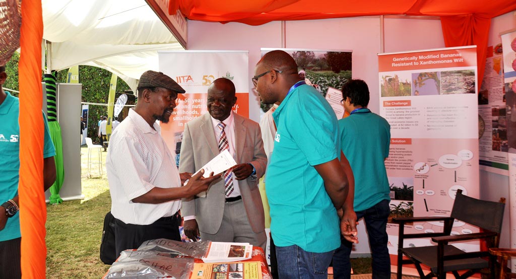 Picture of IITA’s Manyong (middle) hosts guests at the exhibition booth.