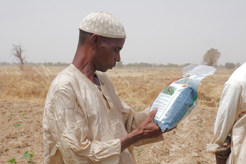  A farmer examining an aflasafe bag during awareness in a community