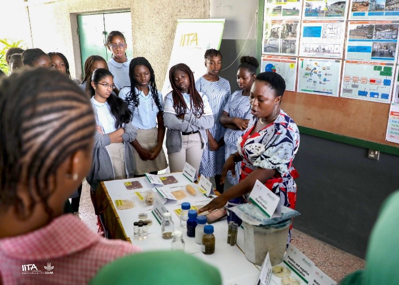 Lab Technician Folasade Oladiti in the Mycotoxin/Pathology Lab explains to girl-students how the biocontrol product Aflasafe works.