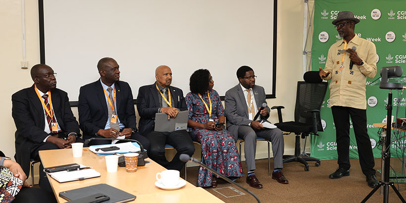 Dr Kwesi Attah-Krah speaking with panelists during the panel session.