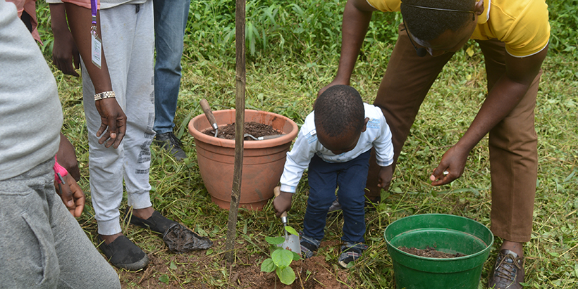 Eager IBC junior member, Jethro Awoyemi, participating in the tree planting ceremony.