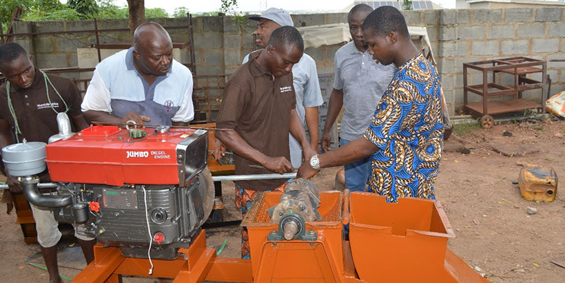 Fabricators constructing the wet hammer mill, supervised by IITA Postharvest Specialist Peter Kolawole (center background)