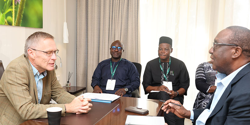 IFAD Associate Vice-President, Program Management Department, Dr. Donal Brown discussing with Dr. Simeon Ehui, and IITA Rwanda Country Representative Dr. Abdou Konlambigue, and Dr. Kehinde Makinde in the background