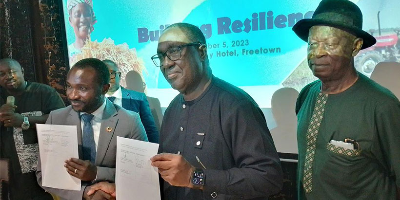 IITA Director General and CGIAR Regional Director for Continental Africa, Dr Simeon Ehui with Sierra Leone Minister of Agriculture, Honourable Henry Kpaka displaying the signed MoU, and Dr Alfred Dixon (r)