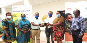 Mwananchi’s Business Manager, Jackson Tarimo and Business Executive, Livin Joseph, presenting the award to the IITA Personnel Officer, Edith Kazimoto. Looking on from left are IITA staff: Catherine Njuguna, Regina Kapinga and (right) Freddy Baijukya.