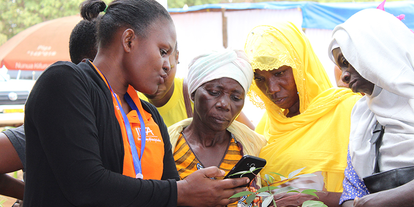 IITA executive Ass. Director’s office, Veronica Kebwe showing how to use Nuru App to visitors at IITA booth. Photo: Hadi/IITA
