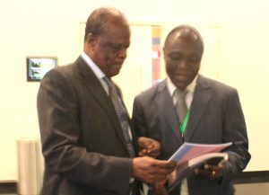 Picture of Denis handing IITA annual report to the Minister.