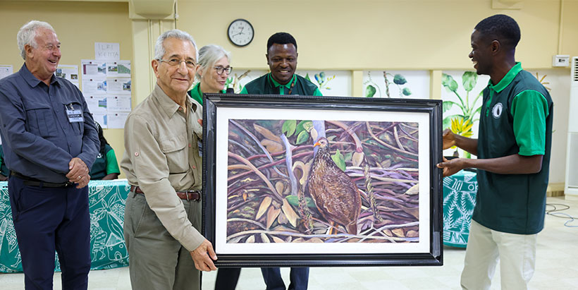 Legendary Anastasio Paul Leventis (L) receiving a hand-painted art of his favourite bird from the Manager of IITA Forest Center, Adewale Awoyemi (R).