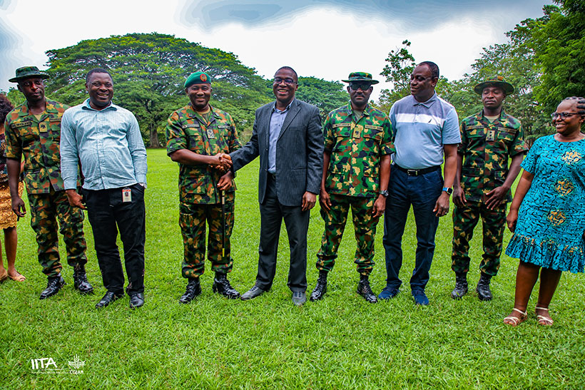 Major General, C R Nnebeife shaking hands with Dr Debo Akande, IITA Director, Partnerships for Development flanked by other NAFARL and IITA representatives.