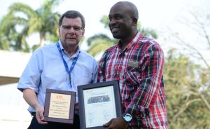 Picture of Kayode Awobajo with the BOT Chair, receives the outstanding team award on behalf of PAO.