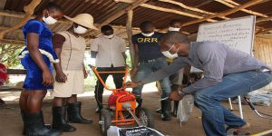 STEP representative showing the parts of a machine to trainees.