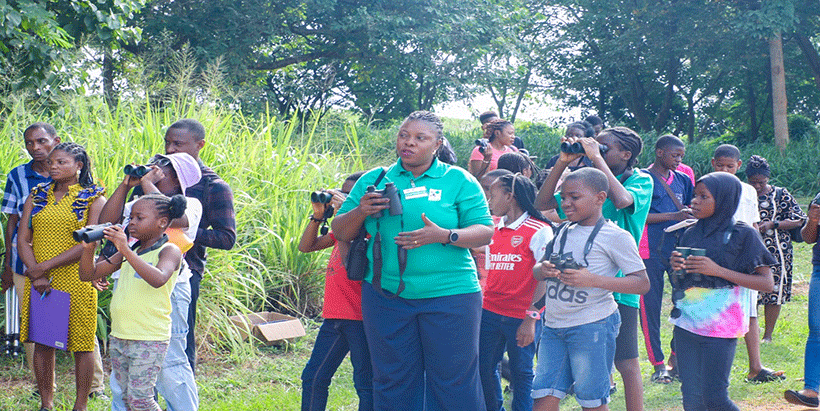 Students Bird Watching at the lakeside using binoculars, with their instructor, Mrs Stella Egbe, of the Nigerian Conservation Foundation.