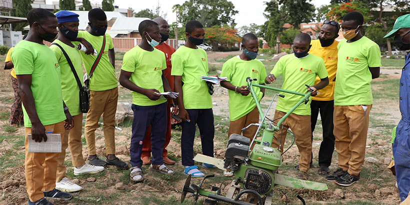 Teachers and students learning the use of farm machines in schools through STEP.